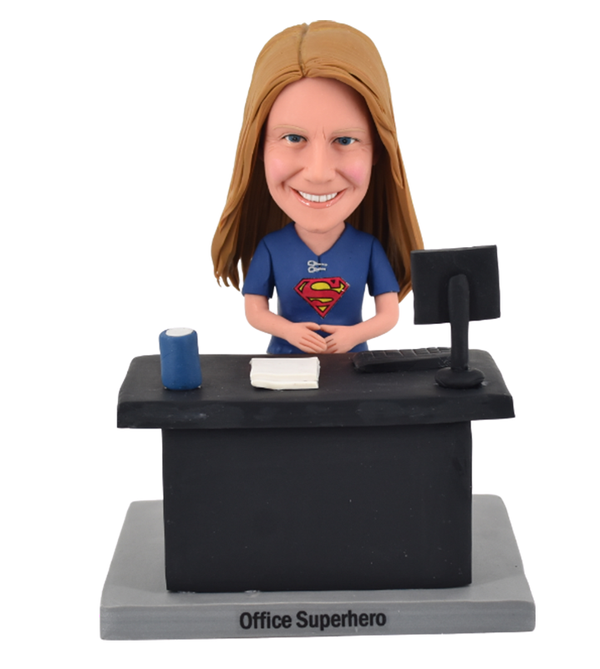 Super woman bobblehead sitting before Desk at work writer