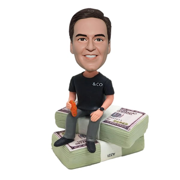 Custom bobblehead sitting on dollars money