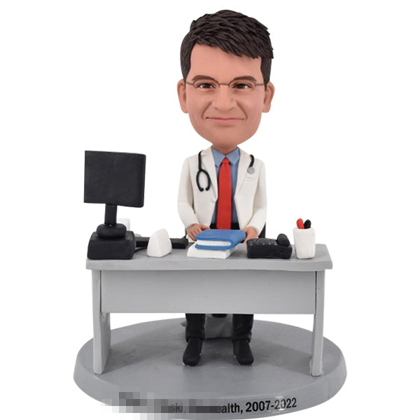 Doctor Bobblehead sitting at his desk with computer